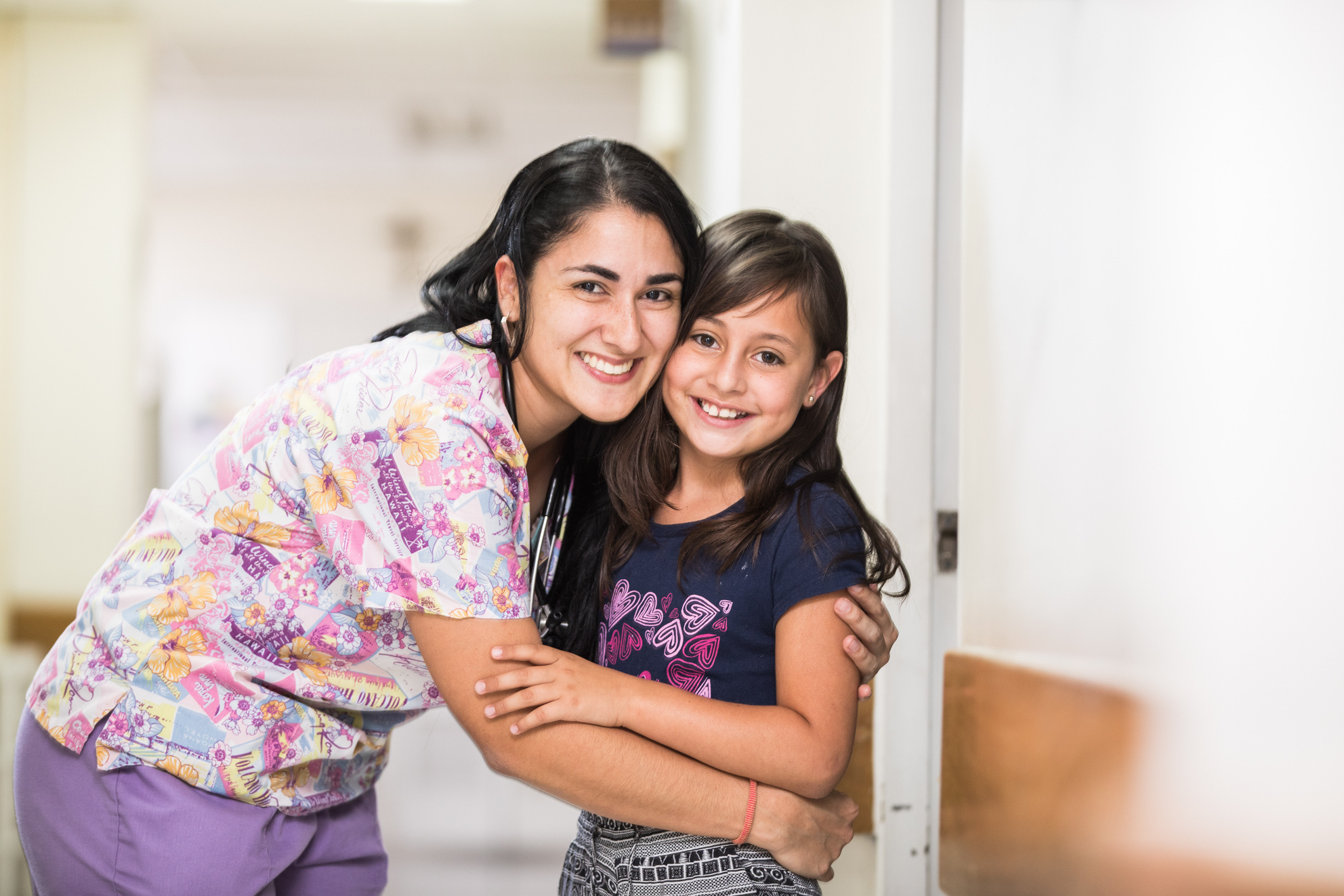 Trabajadora de la salud abrazando a una niña